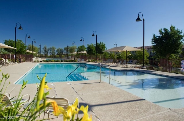 pool featuring fence and a patio area