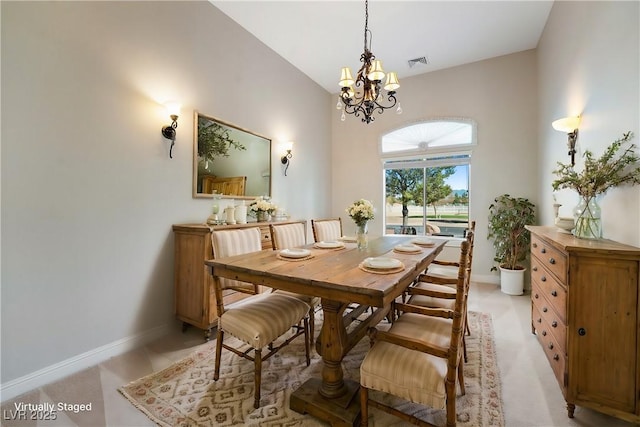 dining space with baseboards, visible vents, an inviting chandelier, and vaulted ceiling