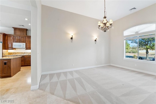 unfurnished dining area featuring a chandelier, baseboards, visible vents, and light carpet