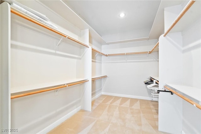 walk in closet featuring light colored carpet