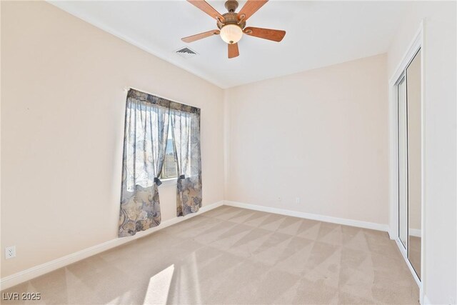 unfurnished room with visible vents, a ceiling fan, baseboards, and light colored carpet