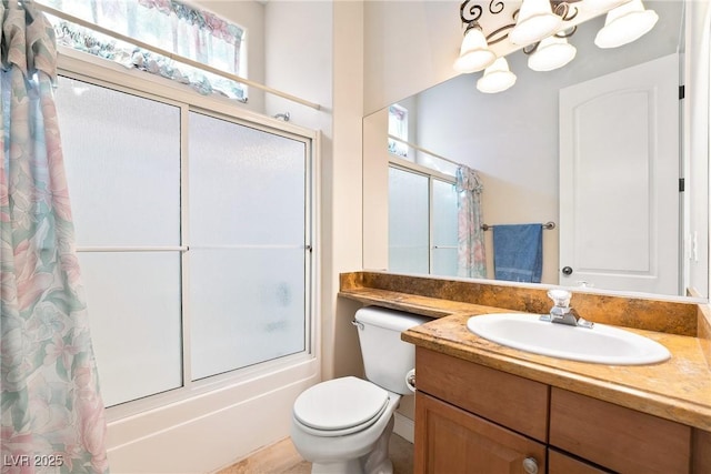bathroom featuring vanity, combined bath / shower with glass door, a chandelier, and toilet