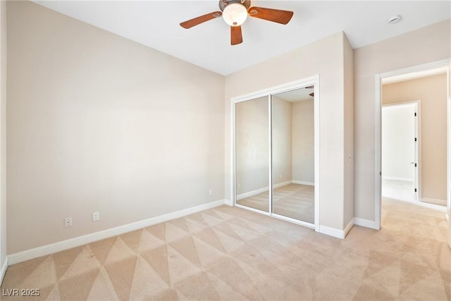 unfurnished bedroom with light colored carpet, baseboards, and a closet