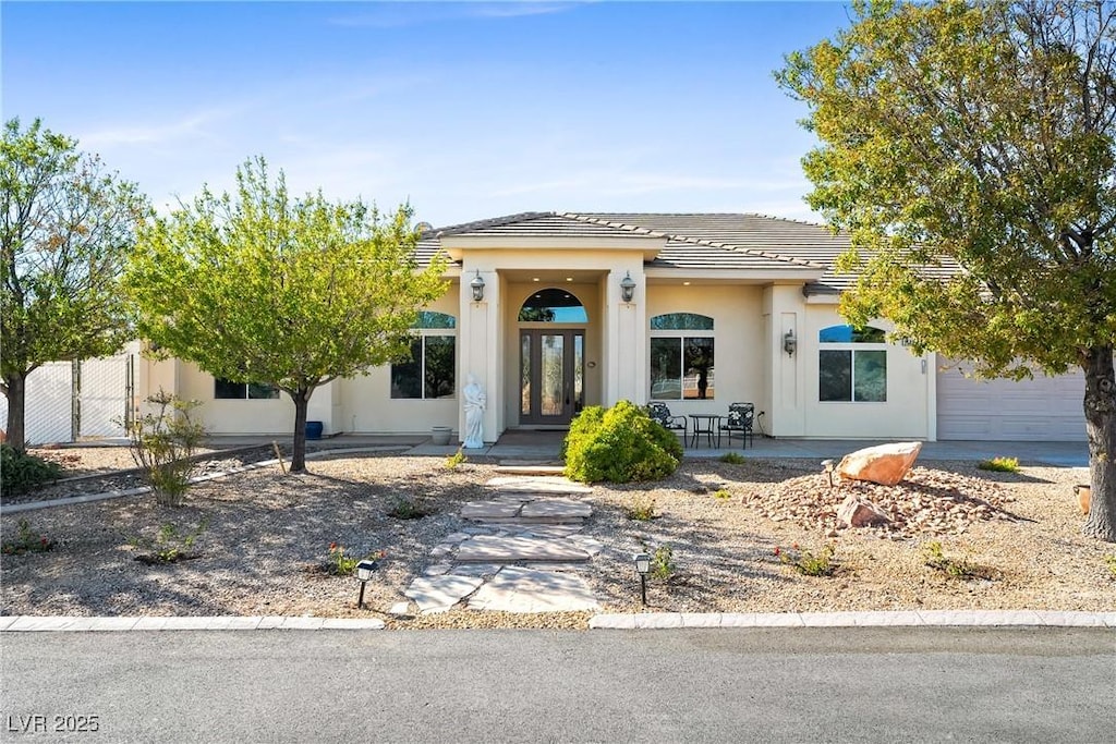 2500 S Zephyr Ave, Pahrump, NV 89048 - view of front of house featuring a tiled roof, a garage, french doors, and stucco siding