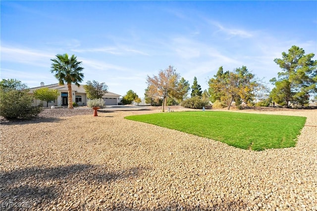 view of yard featuring driveway and a garage