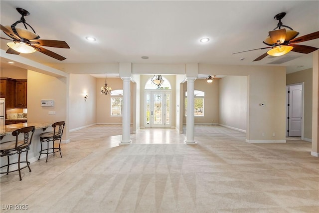 living room featuring baseboards, decorative columns, and recessed lighting