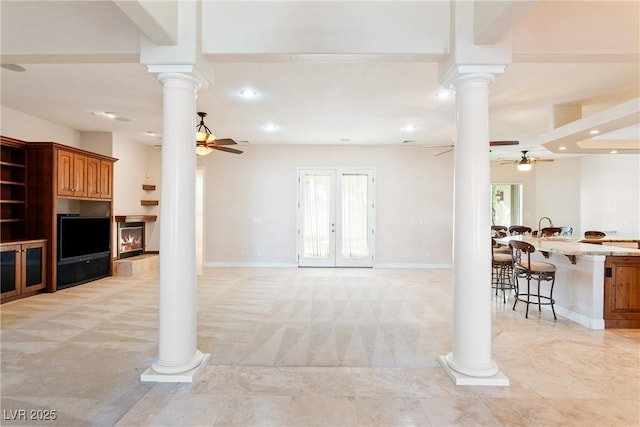 living area featuring ornate columns, a ceiling fan, recessed lighting, and light carpet
