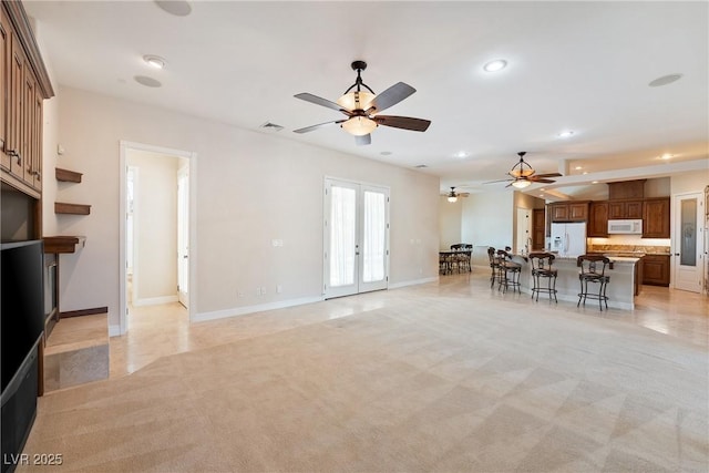 living area with visible vents, ceiling fan, light colored carpet, recessed lighting, and french doors