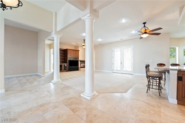 living room featuring french doors, ornate columns, ceiling fan, and baseboards