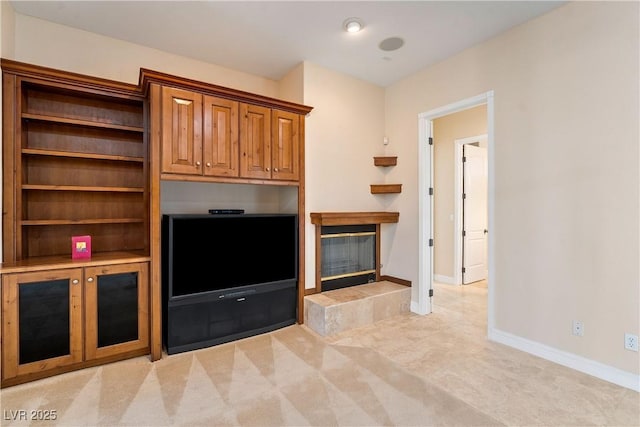 unfurnished living room featuring light colored carpet, baseboards, and a tile fireplace
