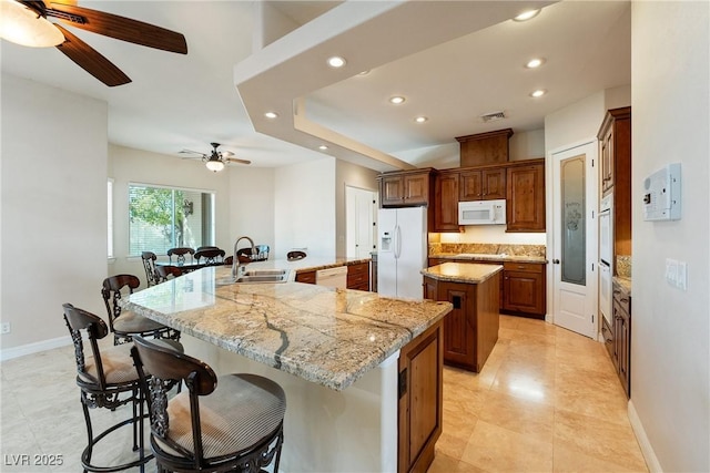 kitchen with white appliances, ceiling fan, a spacious island, recessed lighting, and a sink