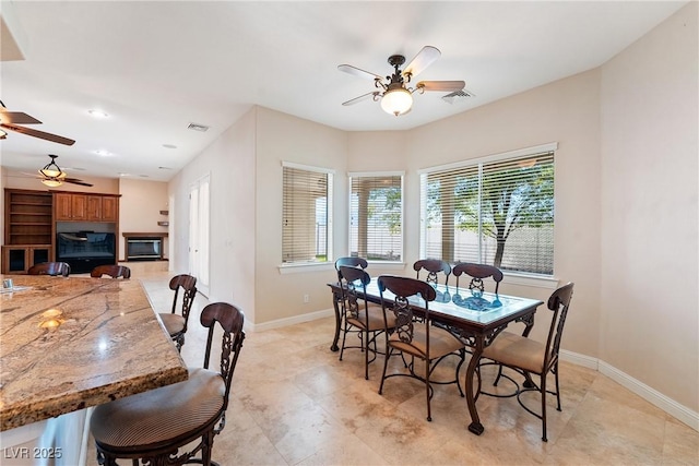 dining area featuring baseboards, a ceiling fan, and visible vents