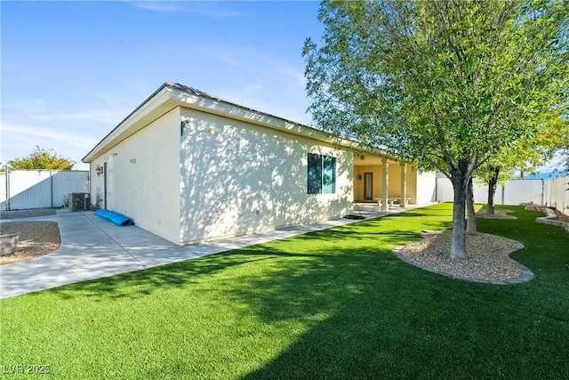 view of home's exterior featuring a lawn, central air condition unit, a fenced backyard, a patio, and stucco siding