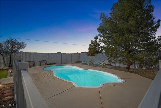 pool at dusk with a fenced in pool, a fenced backyard, and a patio area