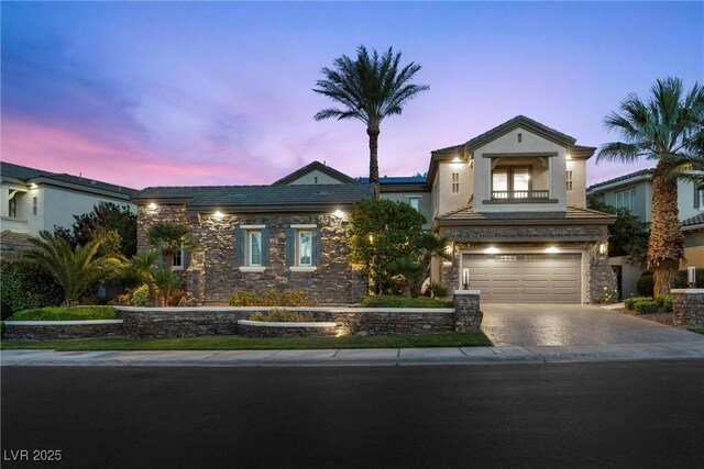 1911 Alcova Ridge Dr, Las Vegas, NV 89135 - view of front of property featuring a garage, stone siding, and concrete driveway