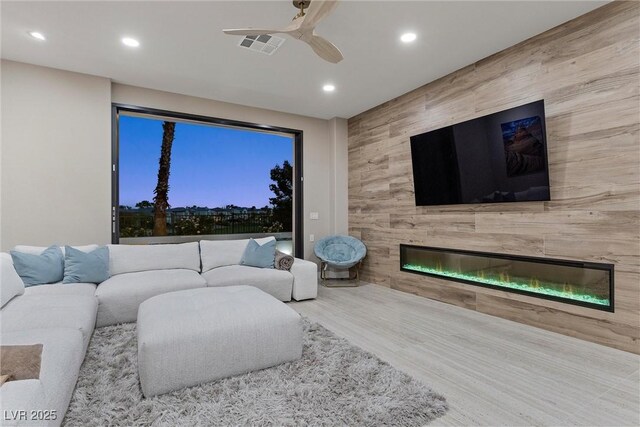 1911 Alcova Ridge Dr, Las Vegas, NV 89135 - living room with visible vents, wood finished floors, recessed lighting, a tiled fireplace, and a ceiling fan