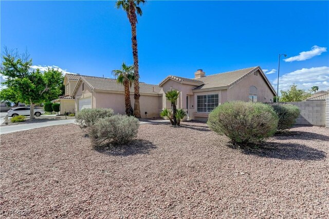 ranch-style home featuring fence, stucco siding, a chimney, and a tile roof