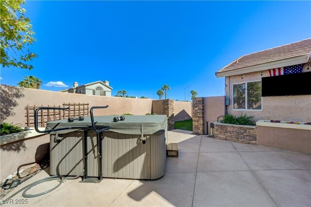 view of patio / terrace featuring a hot tub and a fenced backyard