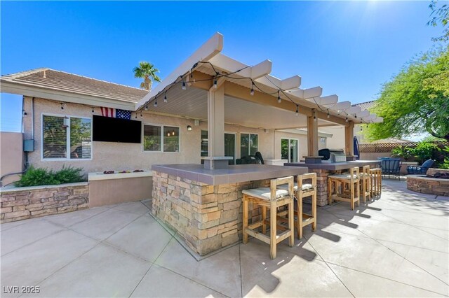 view of patio / terrace with outdoor dry bar and an outdoor fire pit