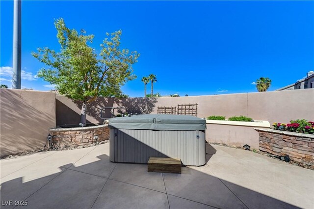 view of patio / terrace featuring a fenced backyard and a hot tub