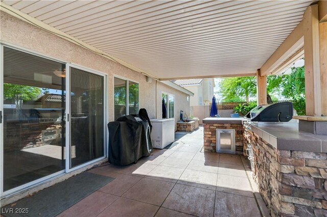 view of patio / terrace with area for grilling, exterior kitchen, and fence