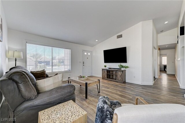 living room featuring a healthy amount of sunlight, baseboards, vaulted ceiling, and visible vents