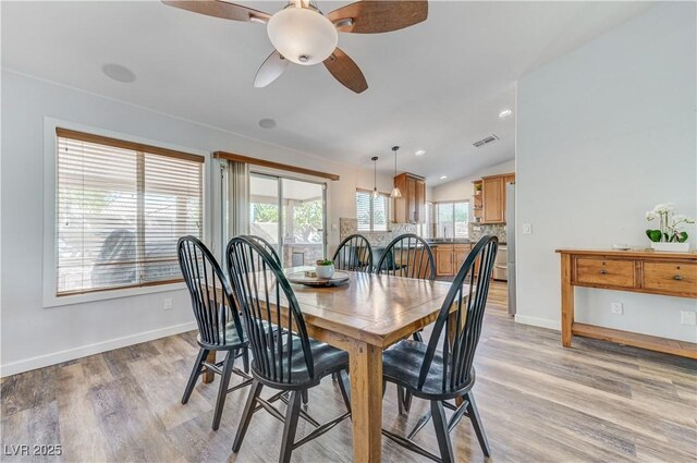 dining area featuring light wood-style floors, baseboards, ceiling fan, and visible vents