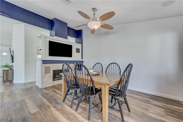 dining space with baseboards, ceiling fan, visible vents, and wood finished floors