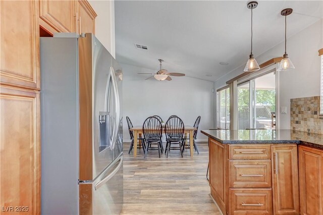 kitchen with ceiling fan, hanging light fixtures, light wood-style floors, stainless steel refrigerator with ice dispenser, and visible vents