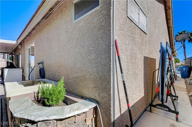 view of side of property with fence and stucco siding