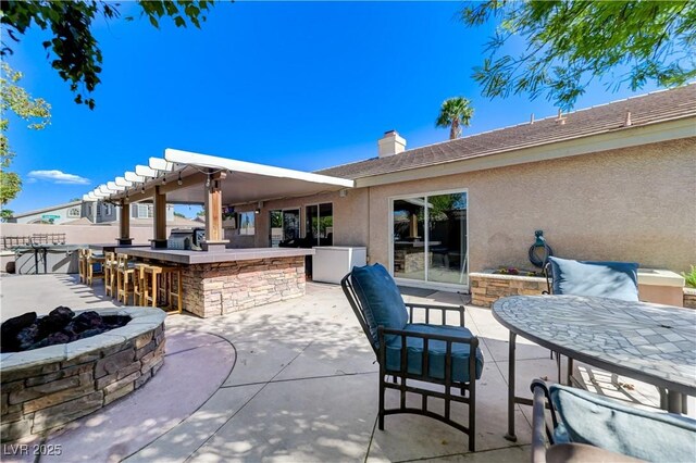 view of patio / terrace featuring an outdoor fire pit and outdoor dry bar