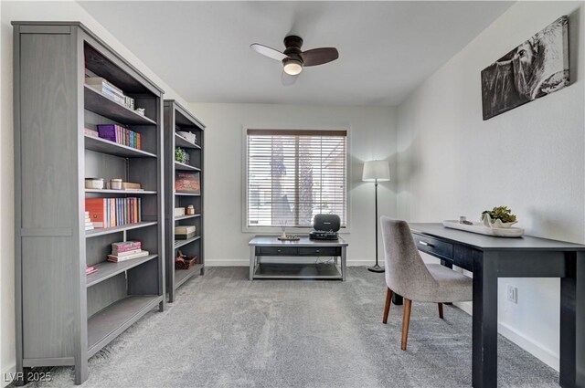 carpeted office featuring baseboards and a ceiling fan