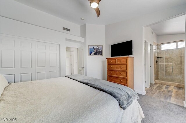 bedroom featuring a closet, carpet floors, visible vents, ceiling fan, and connected bathroom
