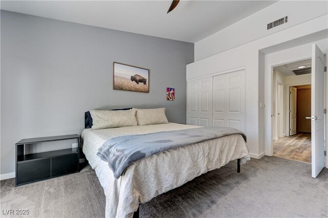 bedroom featuring a closet, carpet, baseboards, and visible vents