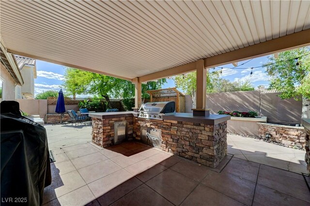 view of patio / terrace featuring an outdoor kitchen, a fenced backyard, and grilling area
