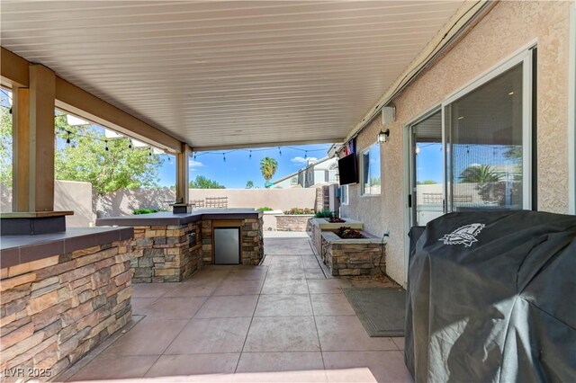 view of patio / terrace with a fenced backyard, outdoor dry bar, a grill, and area for grilling