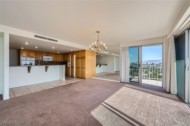 3111 Bel Air Dr Unit 18B, Las Vegas, NV 89109 - unfurnished living room featuring visible vents, recessed lighting, light colored carpet, a chandelier, and light tile patterned floors