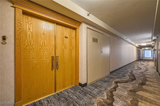 3111 Bel Air Dr Unit 18B, Las Vegas, NV 89109 - corridor with a textured ceiling, baseboards, visible vents, and dark colored carpet