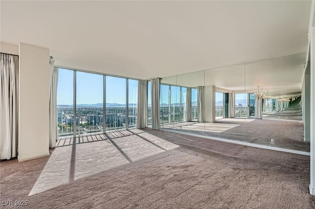 3111 Bel Air Dr Unit 18B, Las Vegas, NV 89109 - carpeted empty room featuring a chandelier, floor to ceiling windows, and a mountain view