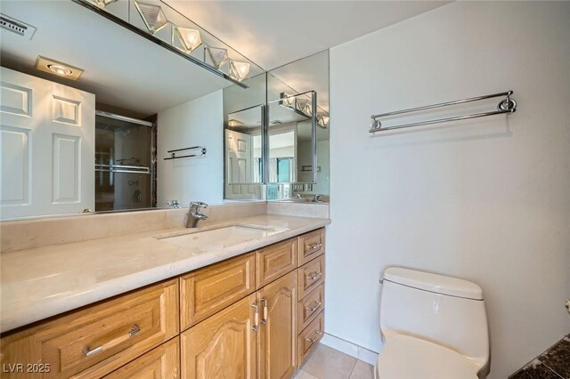 3111 Bel Air Dr Unit 18B, Las Vegas, NV 89109 - bathroom with visible vents, vanity, tile patterned floors, toilet, and a shower with door