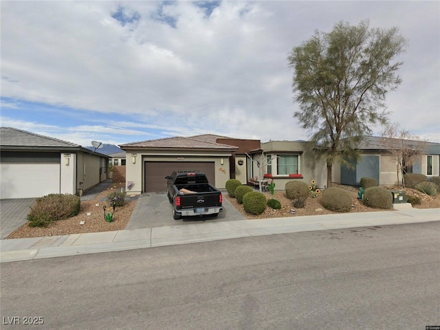 ranch-style house with an attached garage, stucco siding, and driveway