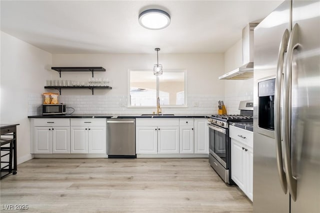 4471 Wisconsin Ave, Las Vegas, NV 89104 - kitchen featuring white cabinets, dark countertops, appliances with stainless steel finishes, a sink, and wall chimney exhaust hood
