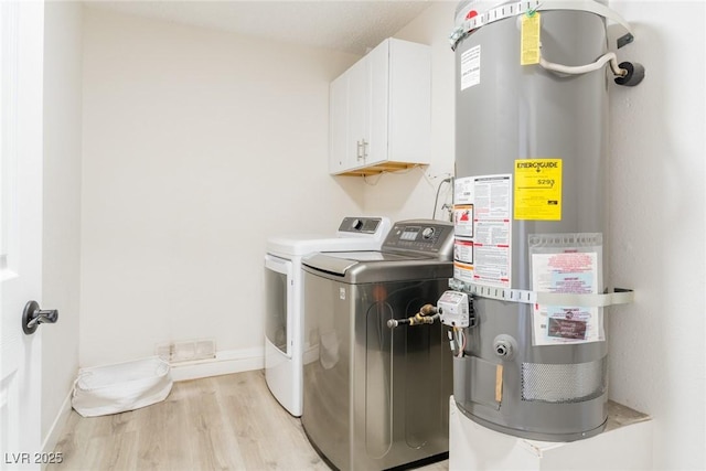 4471 Wisconsin Ave, Las Vegas, NV 89104 - laundry room featuring cabinet space, light wood finished floors, gas water heater, baseboards, and washer and clothes dryer