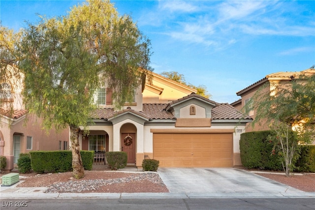 mediterranean / spanish home featuring covered porch, driveway, a garage, stucco siding, and a tiled roof