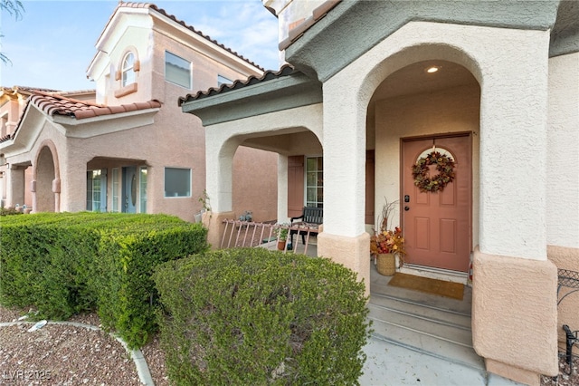 property entrance with a tiled roof and stucco siding