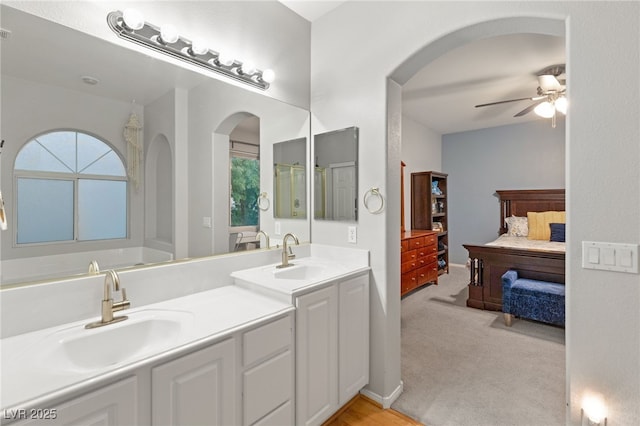 ensuite bathroom featuring double vanity, ensuite bathroom, ceiling fan, and a sink