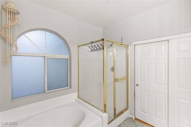 bathroom with a bath and a stall shower