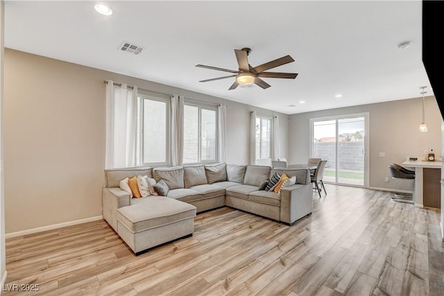 living room featuring a ceiling fan, visible vents, light wood-type flooring, baseboards, and recessed lighting