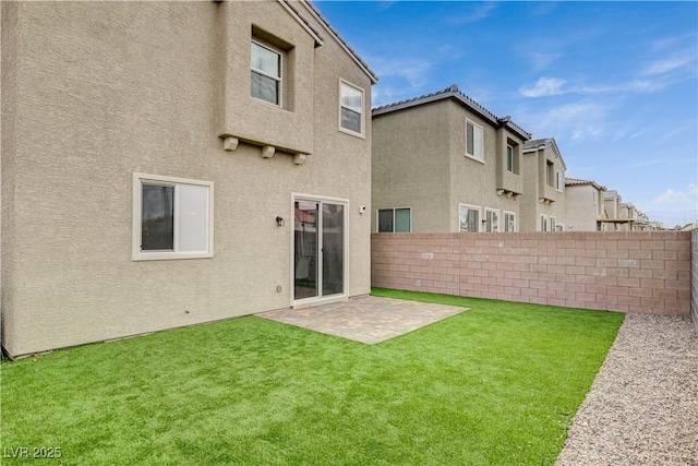back of property featuring fence, a patio, stucco siding, and a yard