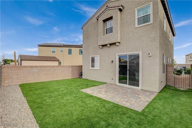rear view of property featuring a yard, a fenced backyard, a patio area, and stucco siding